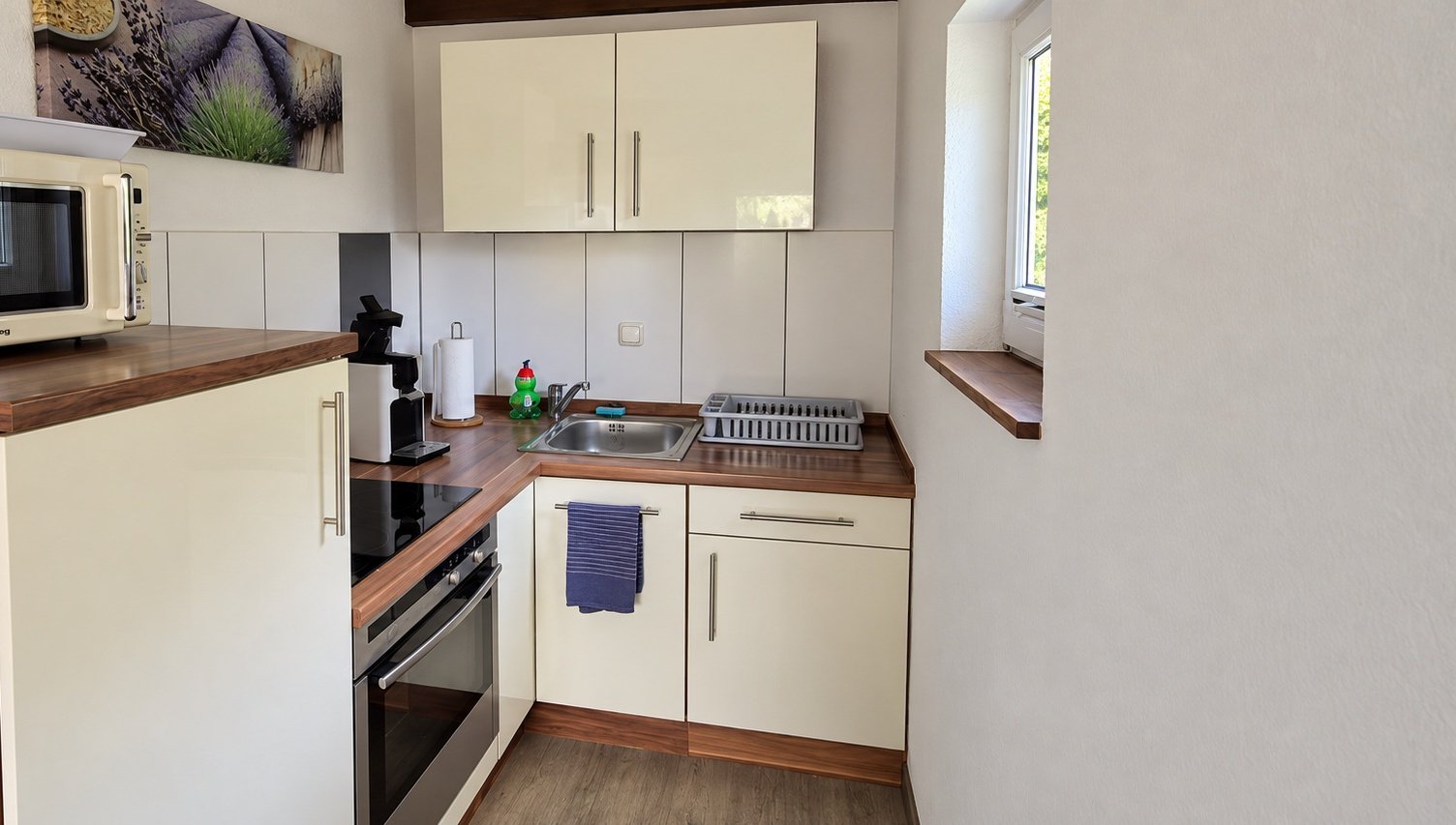 Einbauküche mit Herd, Backofen, Spüle, Kaffeemaschine und Mikrowelle