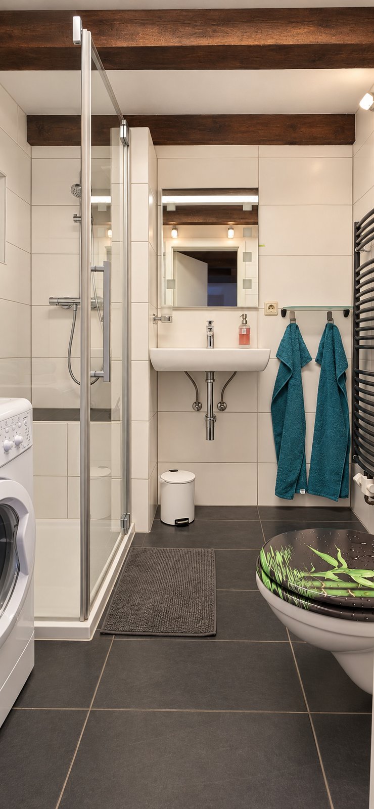 Badezimmer mit Dusche, Waschbecken, WC und Waschmaschine